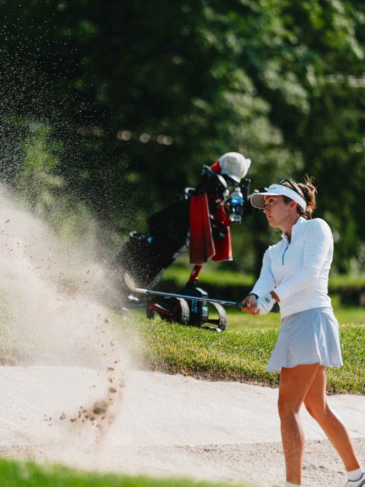 Jillian Hollis splashing a shot out of a bunker